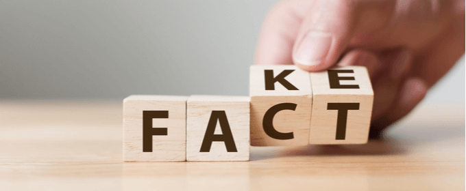 dadi di legno su tavolo con scritta fake che diventa fact