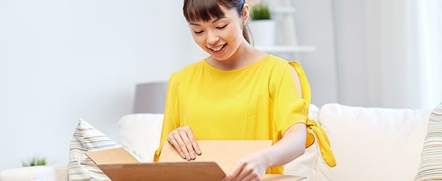 donna con maglione giallo apre un pacco